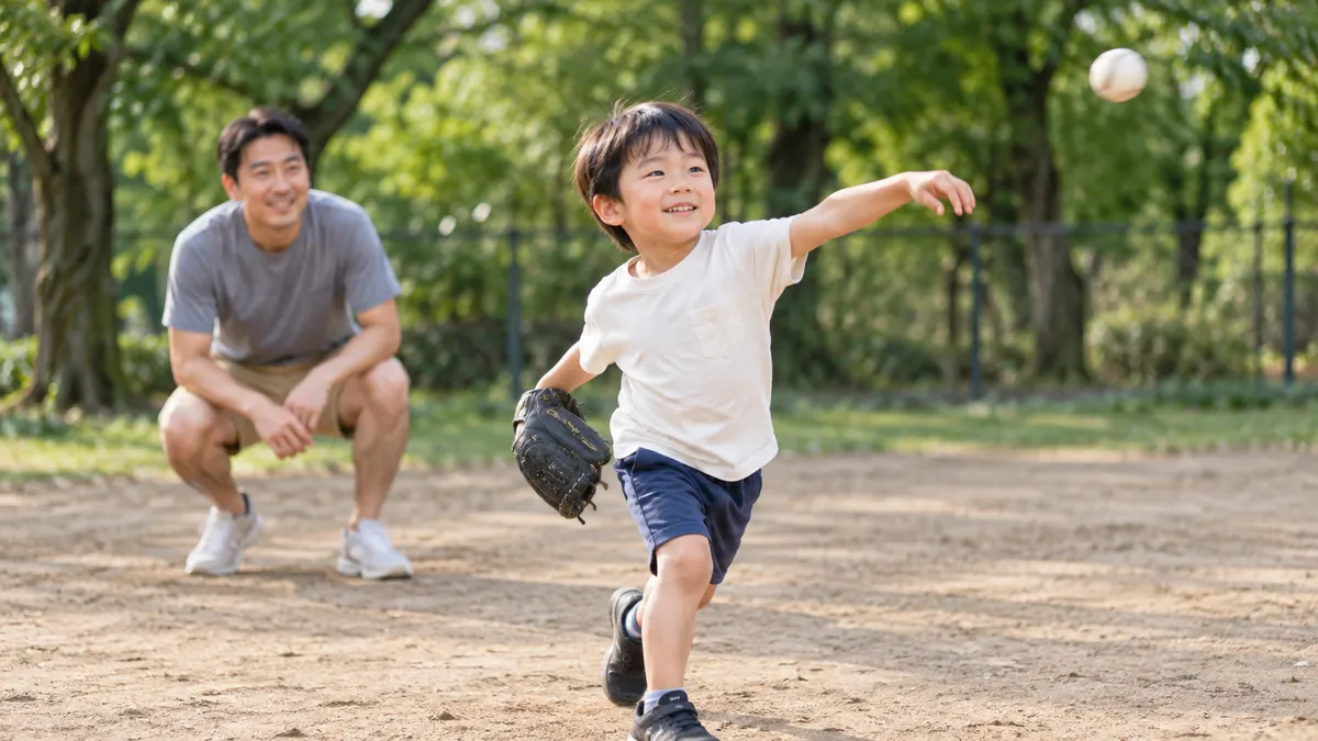 土の公園で左腕を振り切る小柄な少年と見守る父親のイメージ（生成AIによる画像）